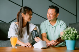 Mature couple measuring blood pressure at home