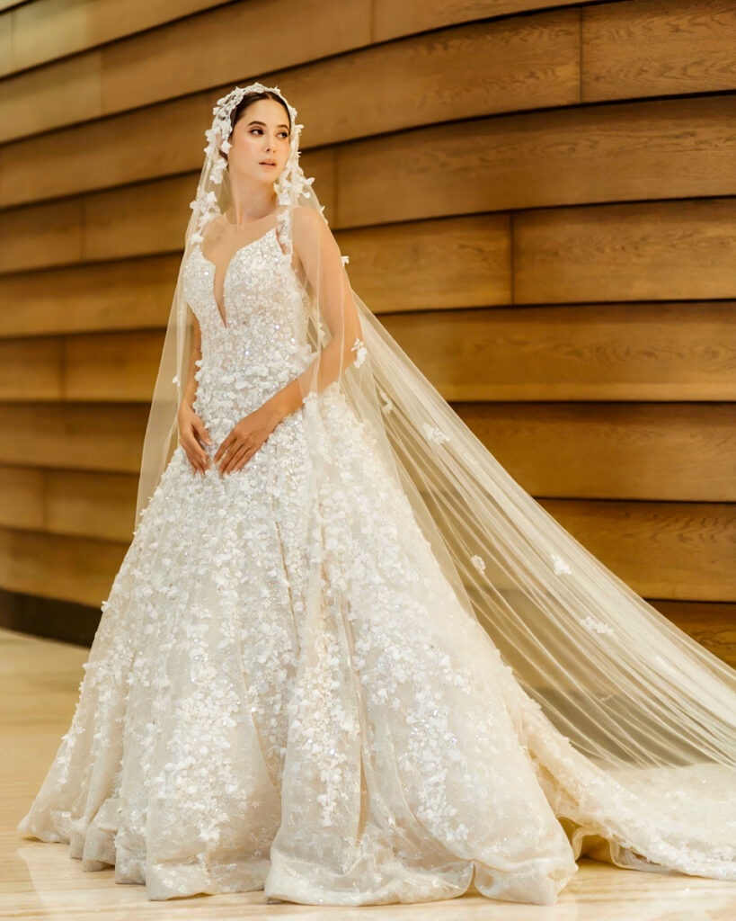 Hannah Kong Bridal Bridal gown with intricate beading paired with a veil adorned with delicate floral accents