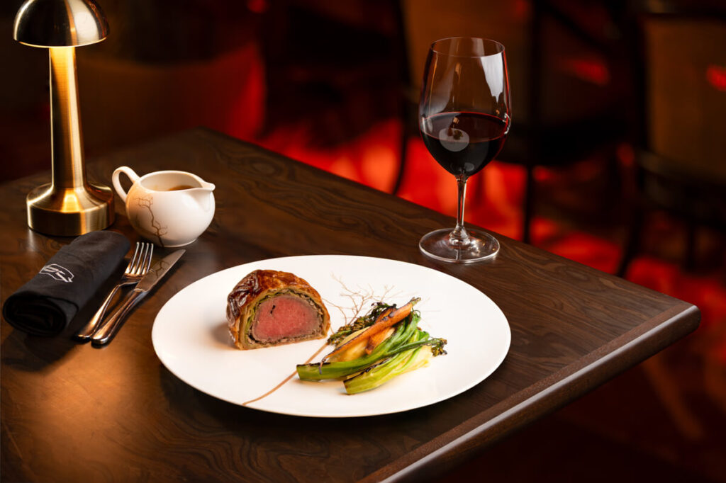 Beef Wellington accompanied with a tender mash broccolini and baby carrots perfect for sharing