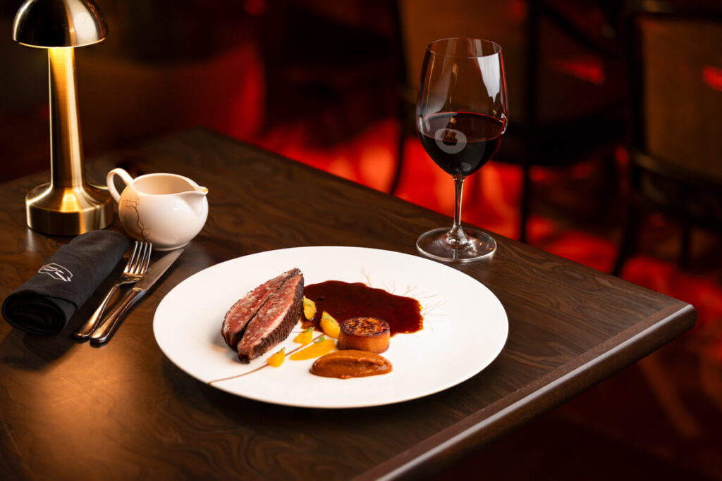 Sous Vide Duck Breast awaits at Quezon Club with a dash of sweet potato orange jus cowboy beans